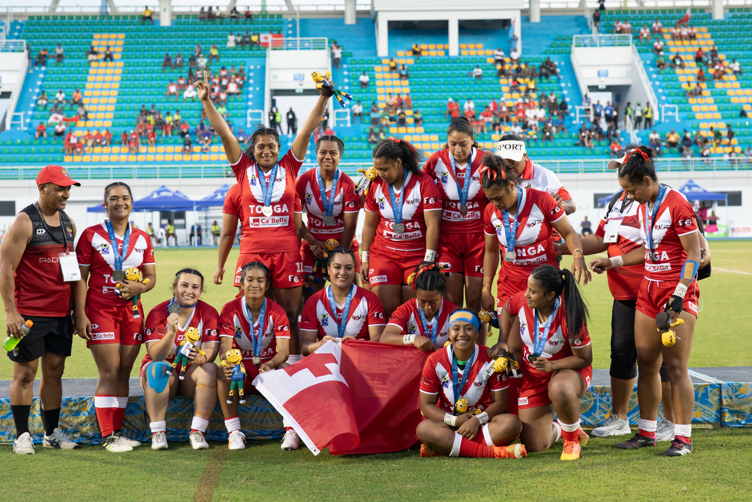 Tongan female rugby league players celebrate winning a medal