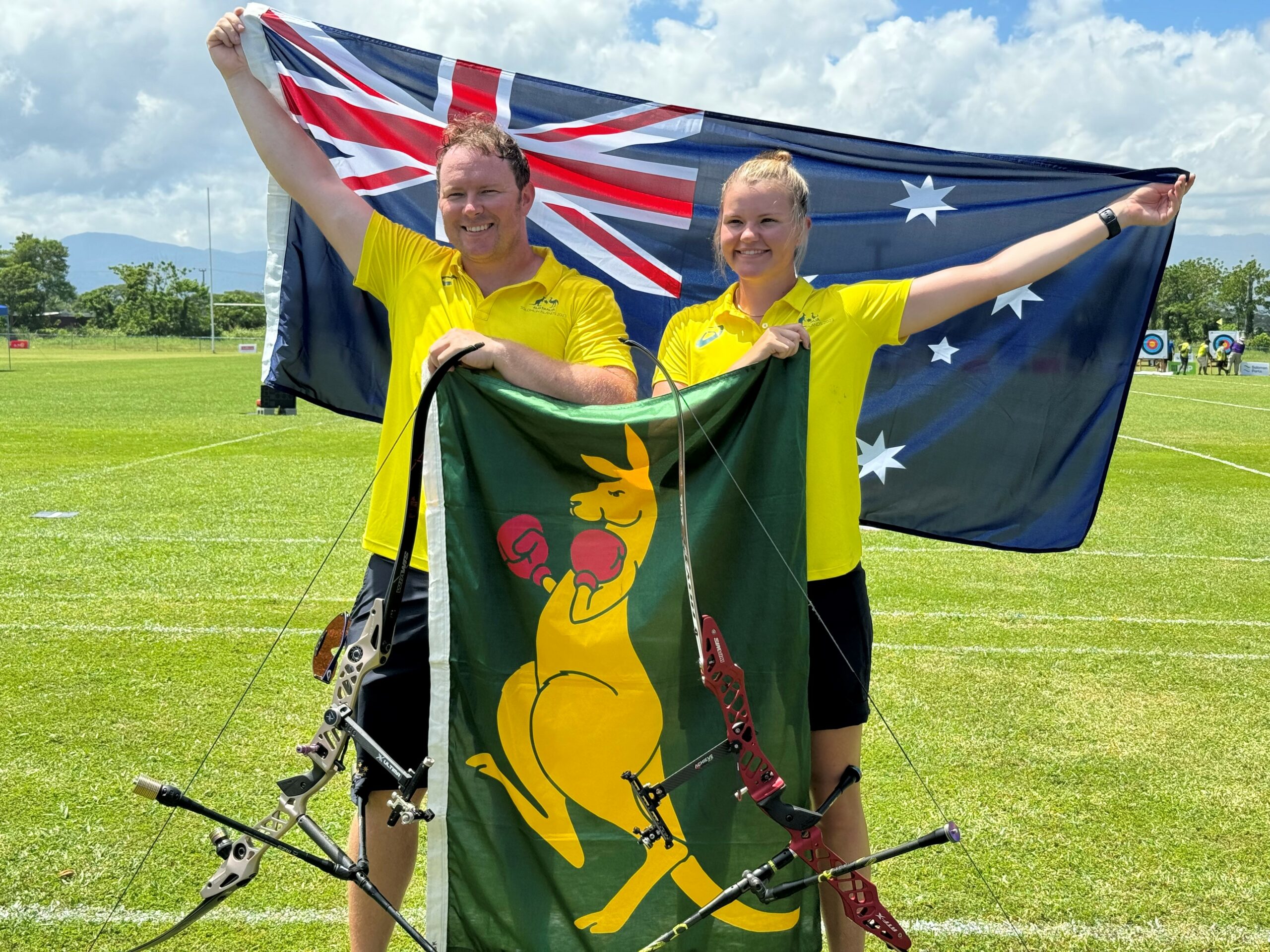 Two archery athletes holding an Australian flag