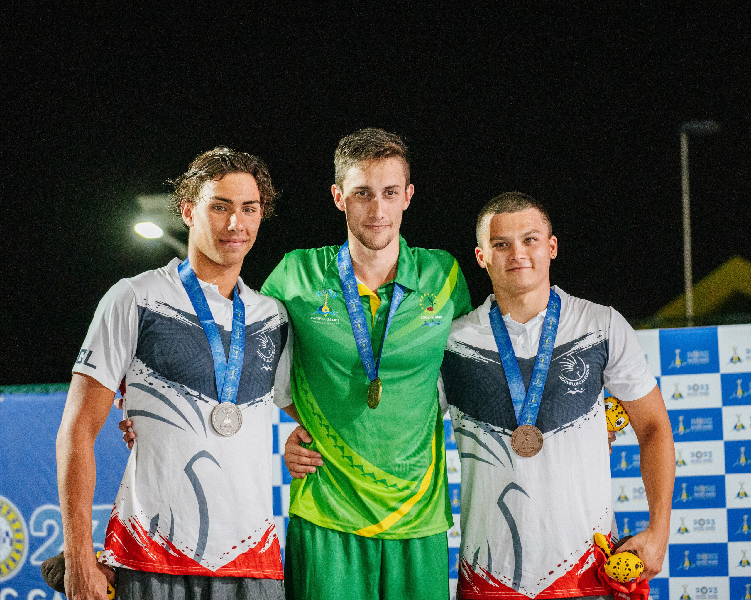 Three male swimmers on a medal podium