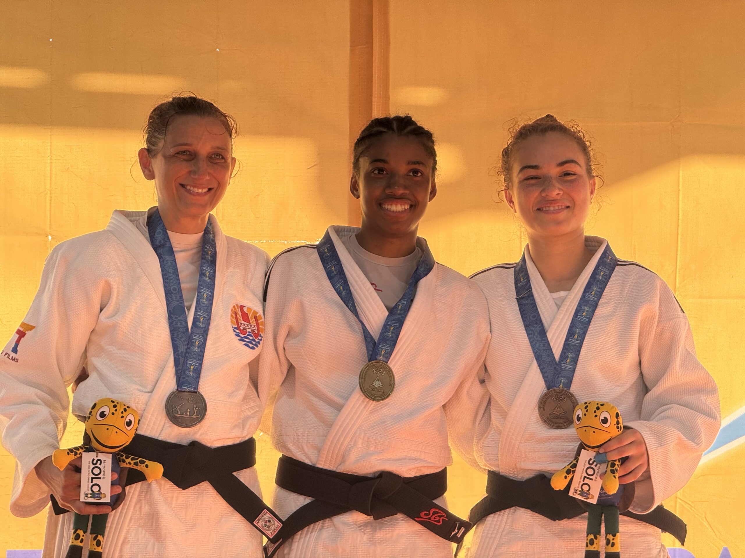 Female judo athletes showcasing medals