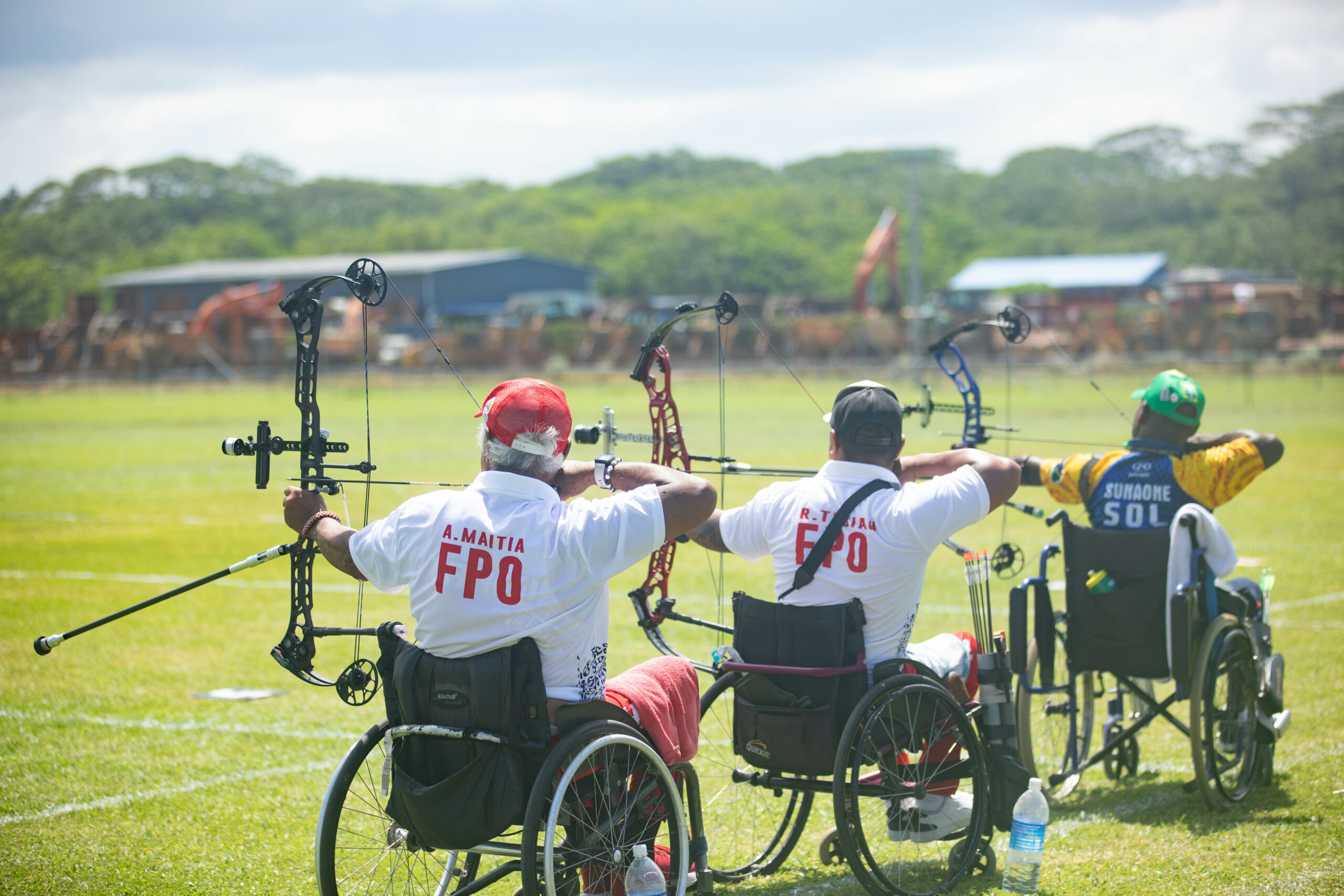People in wheelchairs competing in archery